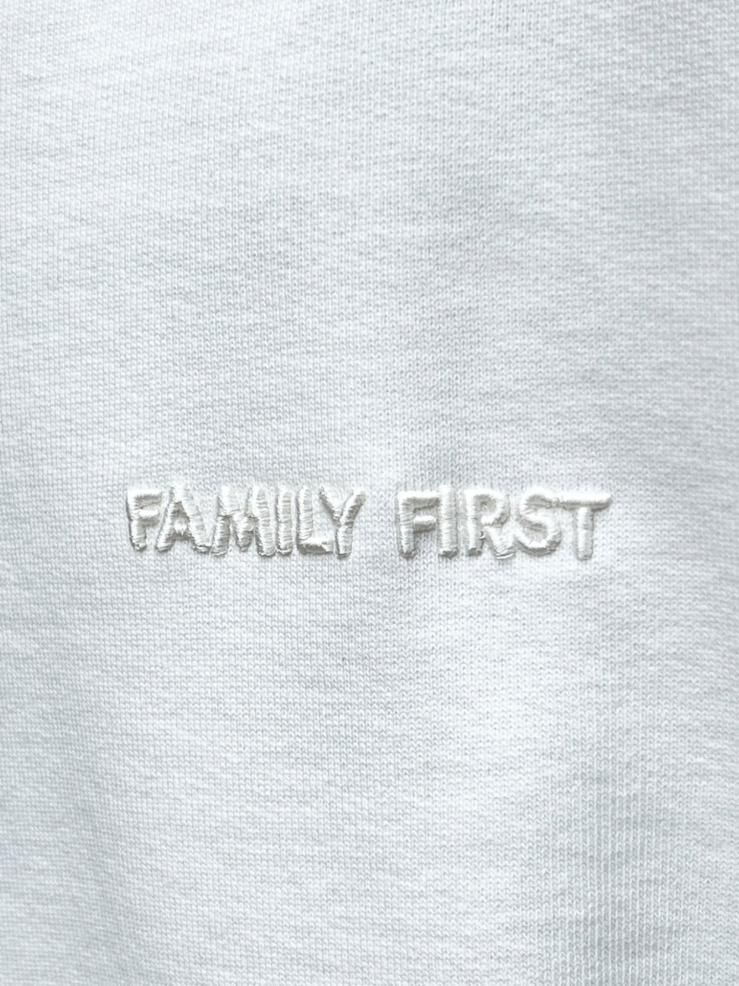 Close-up of FAMILY FIRST 100% cotton fabric with the phrase "family first" embroidered in raised white letters.