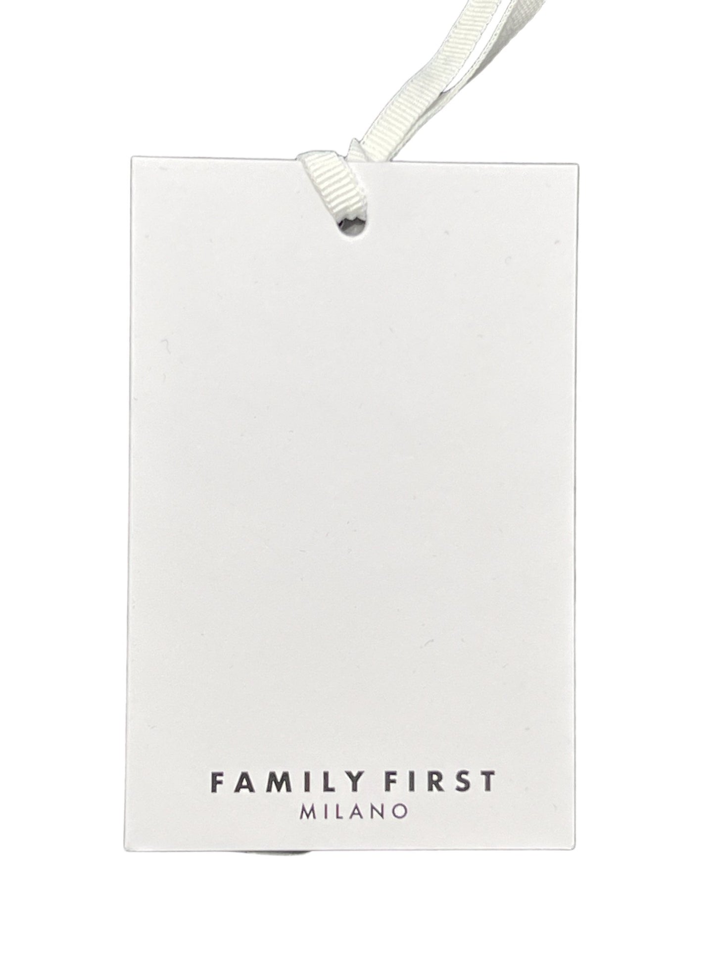 A white tag with the words "FAMILY FIRST TS2415 T-SHIRT BEVERLY HILLS PK" printed at the bottom, attached to a silver grommet and white ribbon, isolated against a black background.