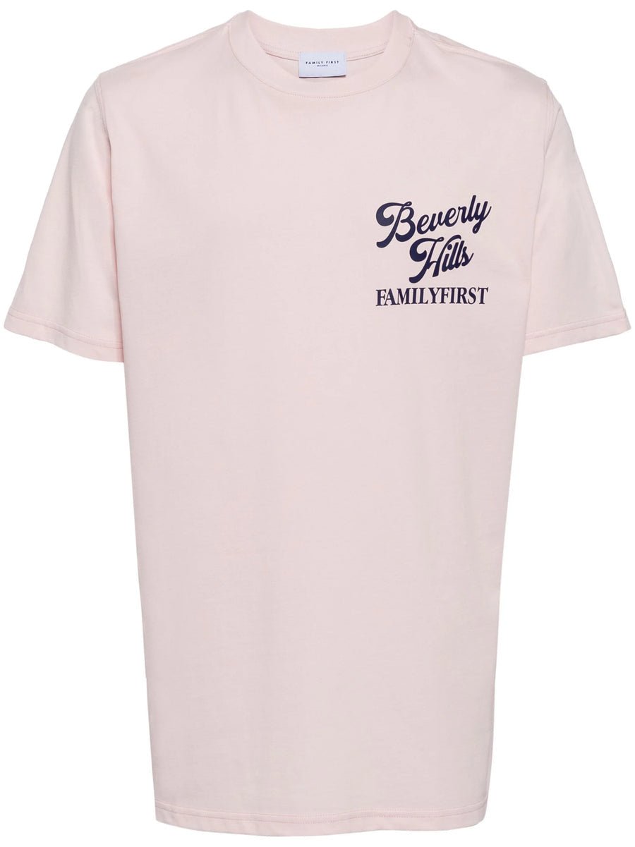 FAMILY FIRST plain pink graphic t-shirt with "beverly hills familyfirst" printed in purple text on the front.