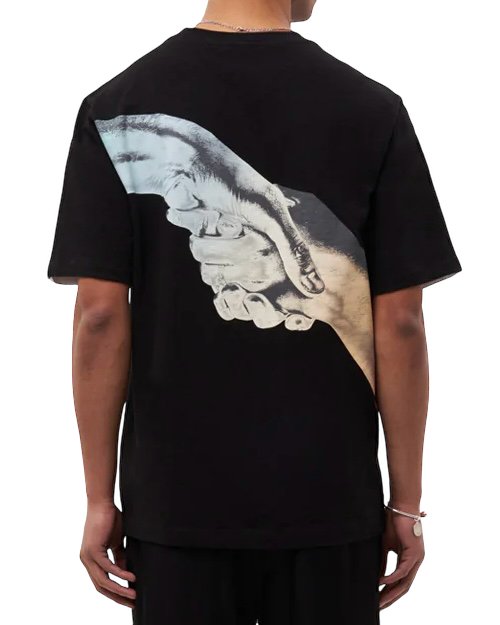 A person from behind wearing a black Filling Pieces Gradient Handshake Tee made of organic cotton with a white graphic of a clasped handshake on the back.