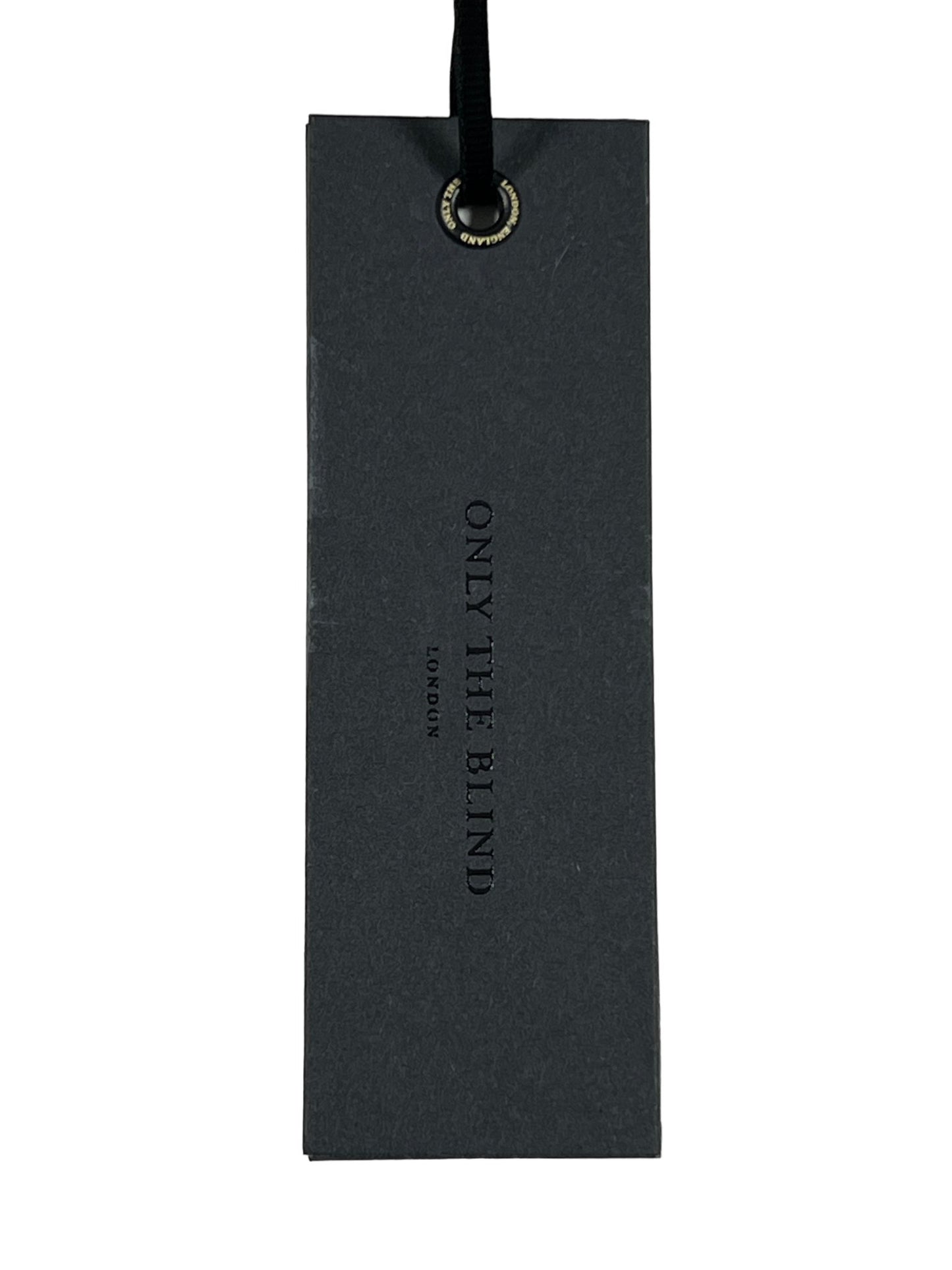 Black clothing tag with sleek black design and silver text "ONLY THE BLIND - BORN IN ENGLAND," accompanied by a black ribbon looped through a metal eyelet.