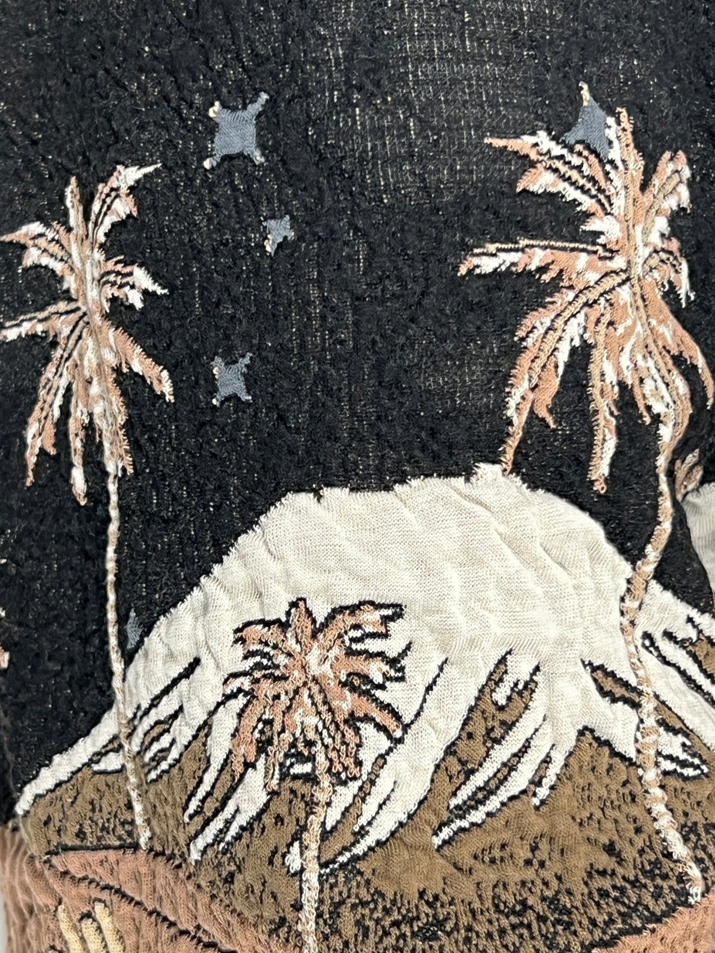 Close-up of a fabric with an embroidered design featuring palm trees, stars, and a large crab on a pair of ONLY THE BLIND OTB-BS1328 SEPIA MOUNTAIN JACQUARD SHORTS BLK.