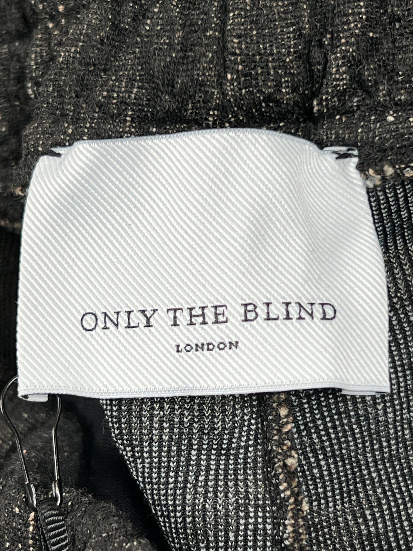 A sleek ONLY THE BLIND label with white text on it.