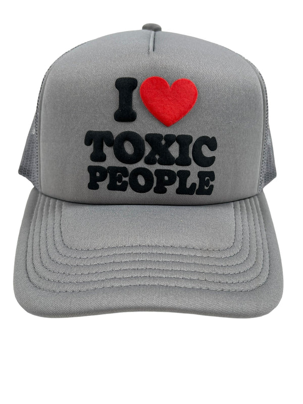 PLEASURES TOXIC TRUCKER CAP GREY with a front design that reads "I ❤️ TOXIC PEOPLE" in black and red text, making it a stylish accessory perfect for casual outings by PLEASURES.
