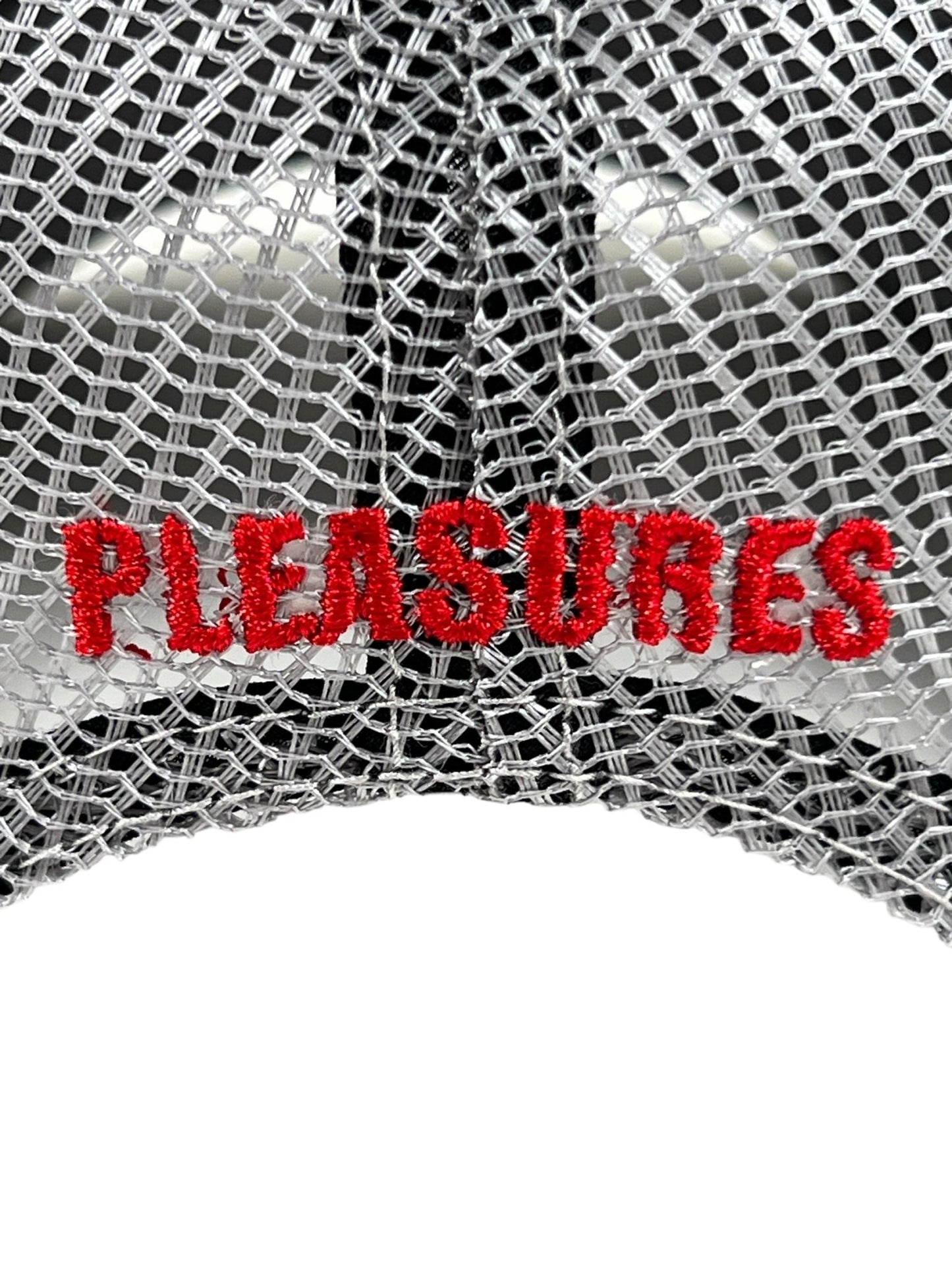 Close-up of a PLEASURES TOXIC TRUCKER CAP GREY with "PLEASURES" embroidered in bold red letters on the front, making it a stylish accessory perfect for casual outings.