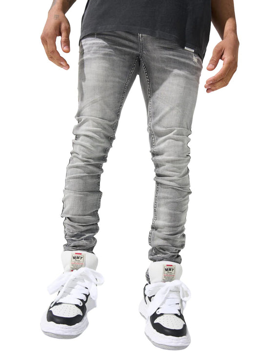 A person standing in SERENEDE® Titan Jeans Grey with a faded grey wash and white high-top sneakers with black accents.