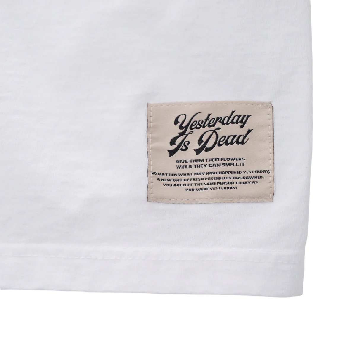 A 100% Cotton white YESTERDAY IS DEAD SUCCULENT TEE with a square graphic label stitched on that reads motivational quotes, including "YESTERDAY IS DEAD," in black lettering.