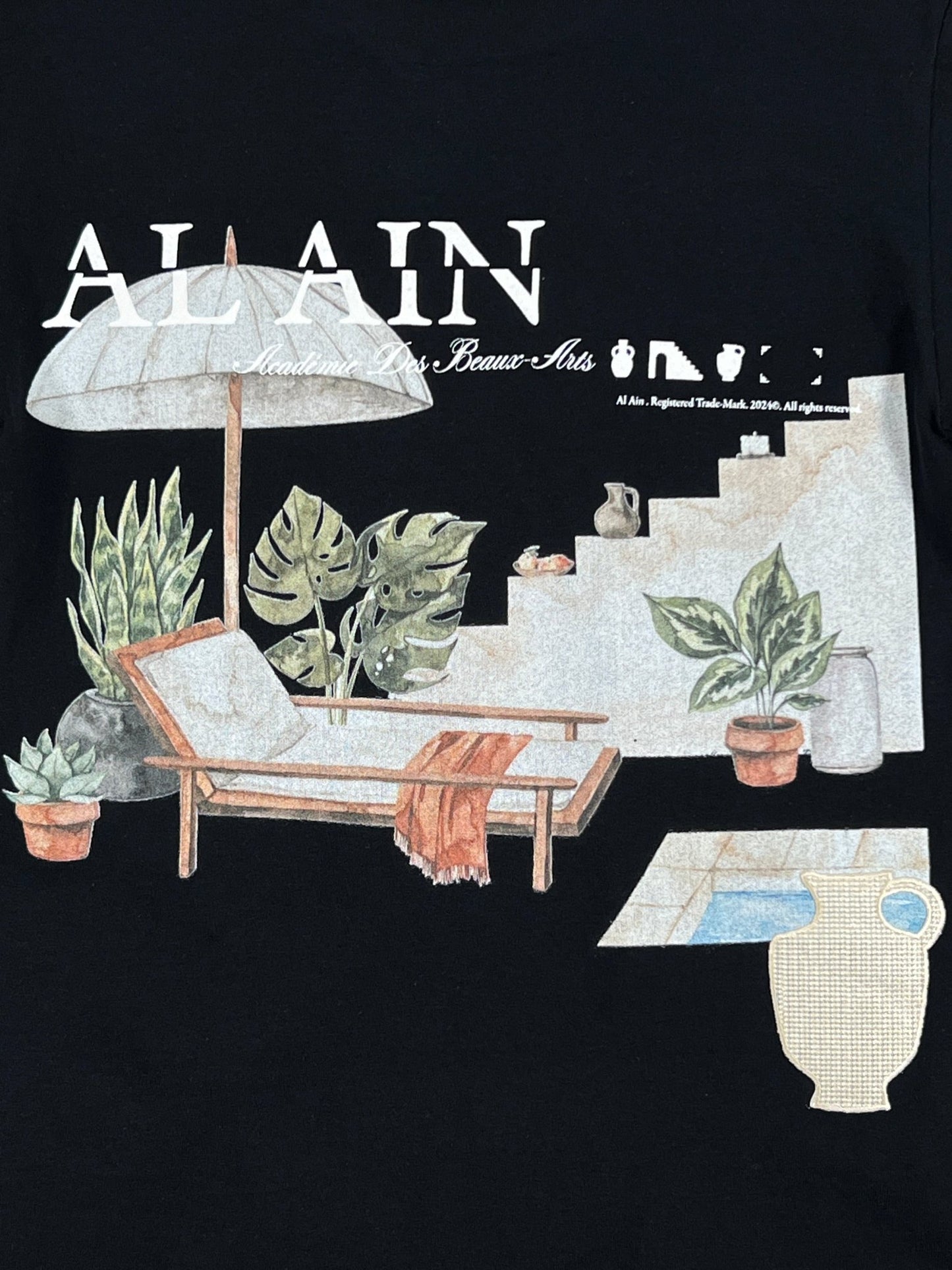 A stylish and eye-catching poolside scene with a lounge chair, umbrella, potted plants, and a stone staircase. Text at the top reads "AL AIN AMHX S124 CHILL NOIR," enhancing the vibe as someone in a graphic t-shirt relaxes nearby.