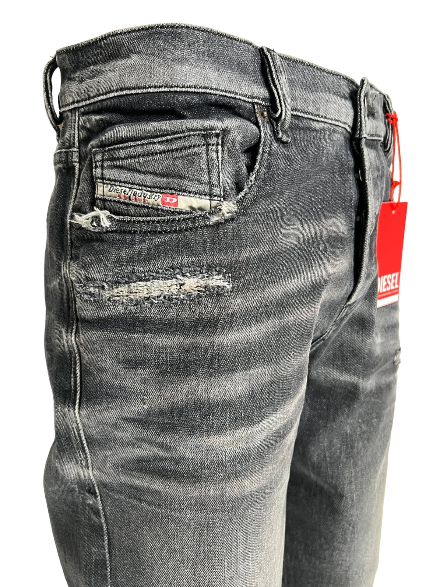A pair of DIESEL men's jeans in a dark blue wash with a tag on them.