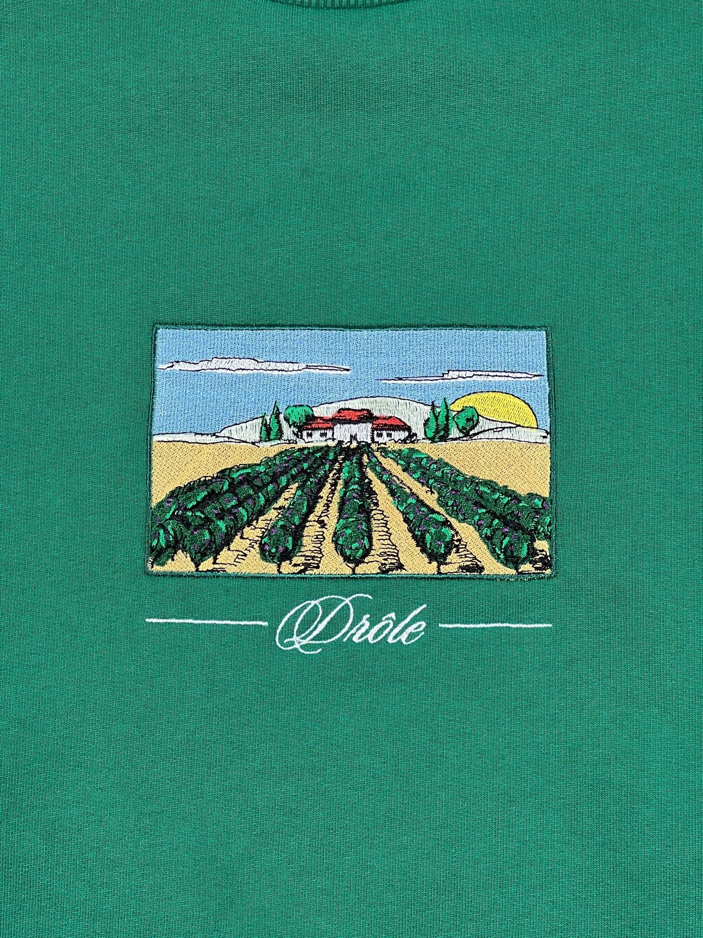 A green DRÔLE DE MONSIEUR French terry fabric t-shirt with an image of a vineyard.