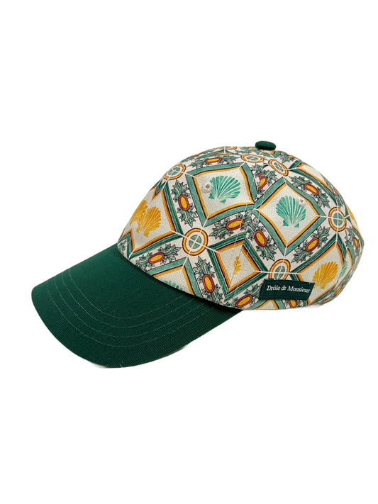 A green and yellow DROLE DE MONSIEUR CP117-CO041 LA CASQUETTE SHELL GREEN baseball hat with a print on it.