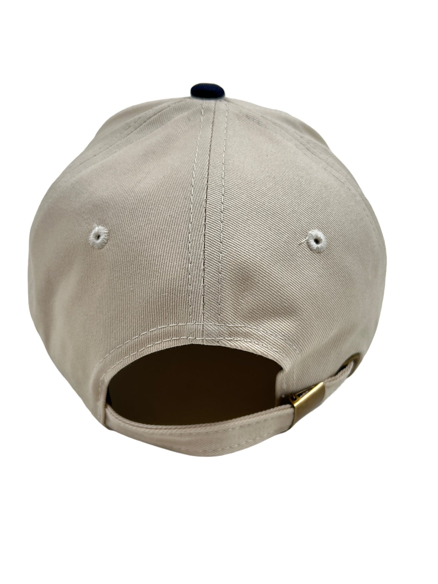 A beige baseball cap with a blue buckle and the word "FAMILY FIRST HF2402 HAT MALIBU WH" embroidered on it by FAMILY FIRST.