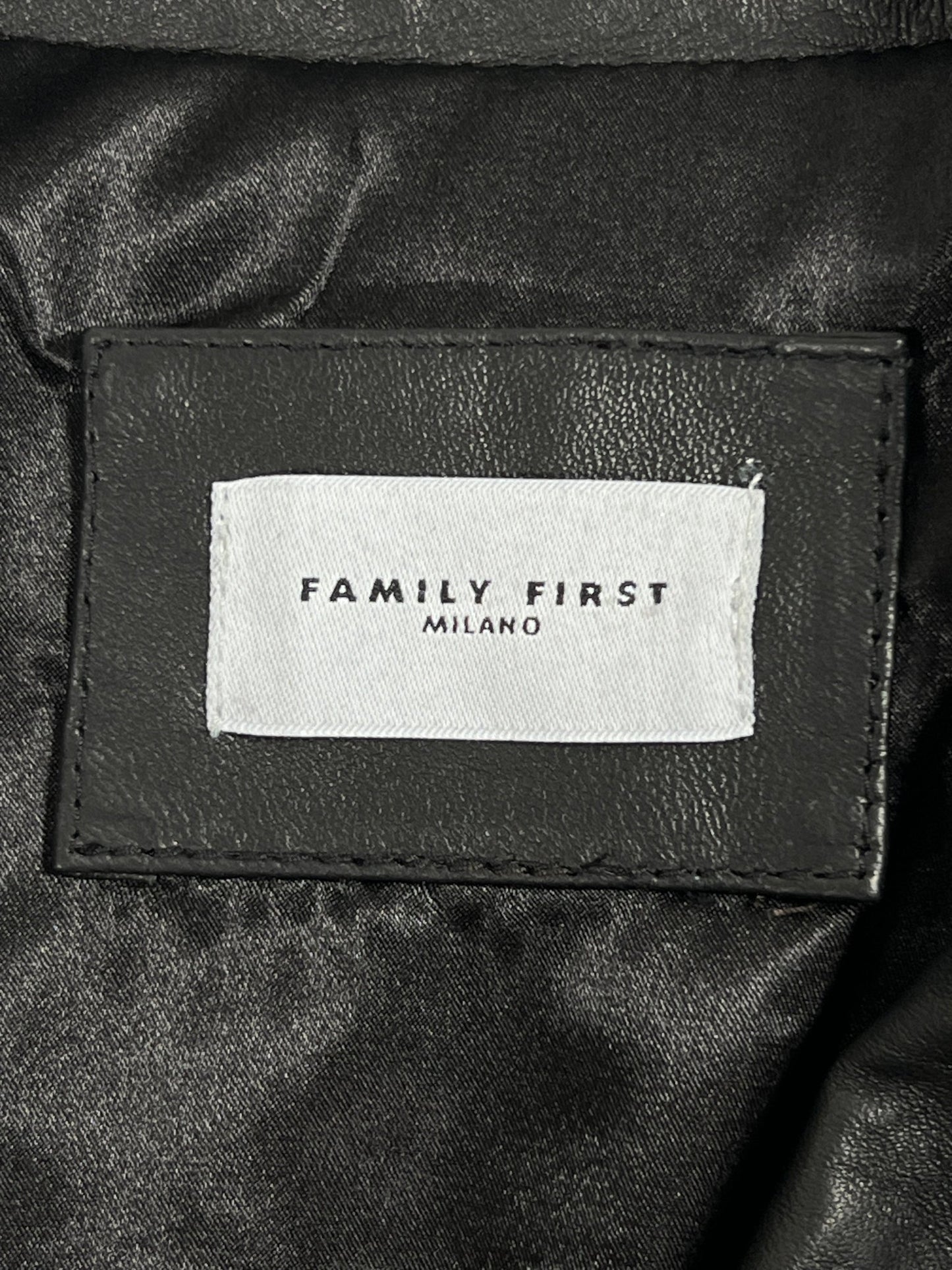 A black vegan leather biker jacket from FAMILY FIRST with a label that says family first.
