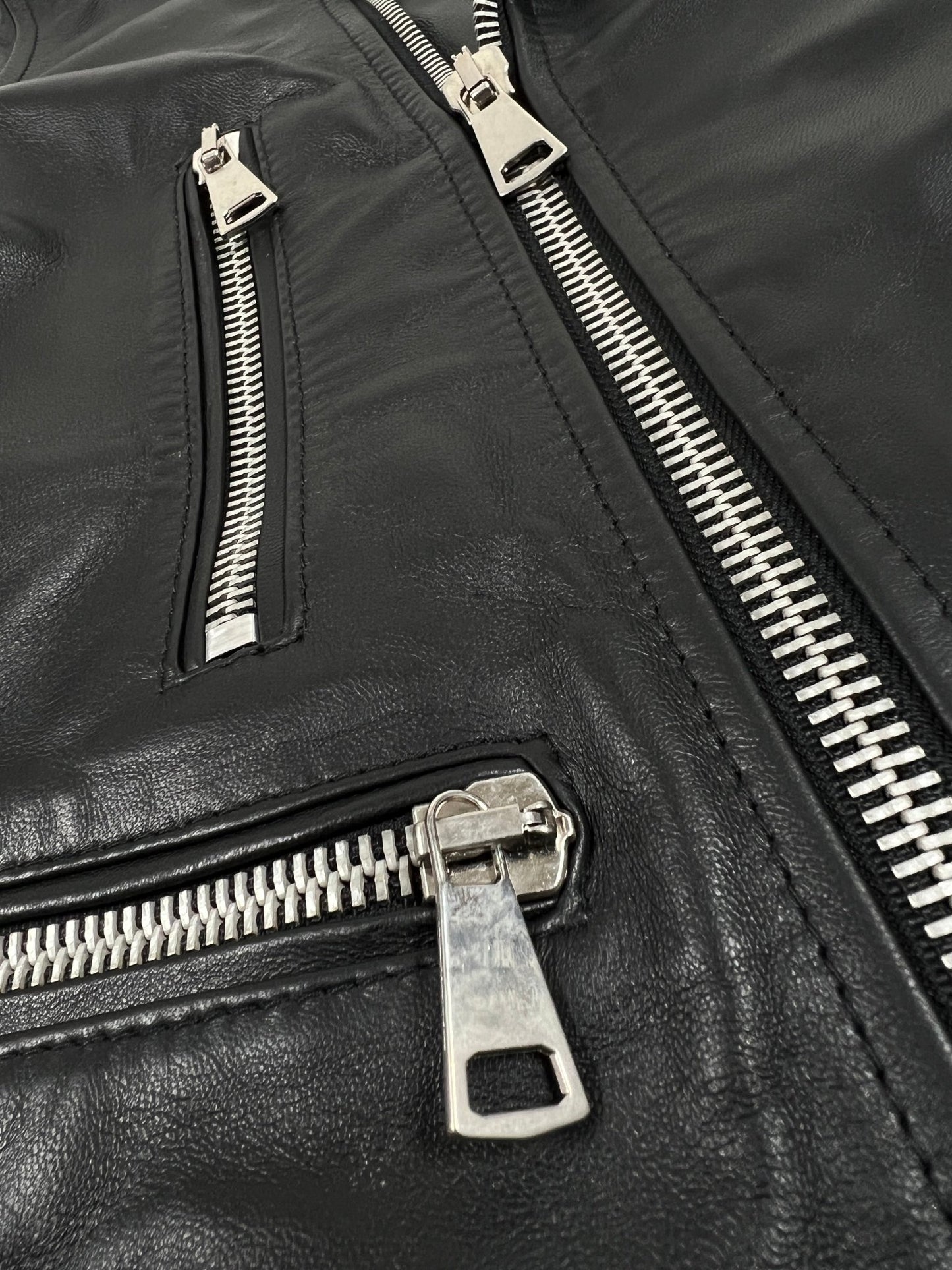 A close up of a FAMILY FIRST JLS2304BK BIKER VEGAN LEATHER JACKET BLACK with zippers.