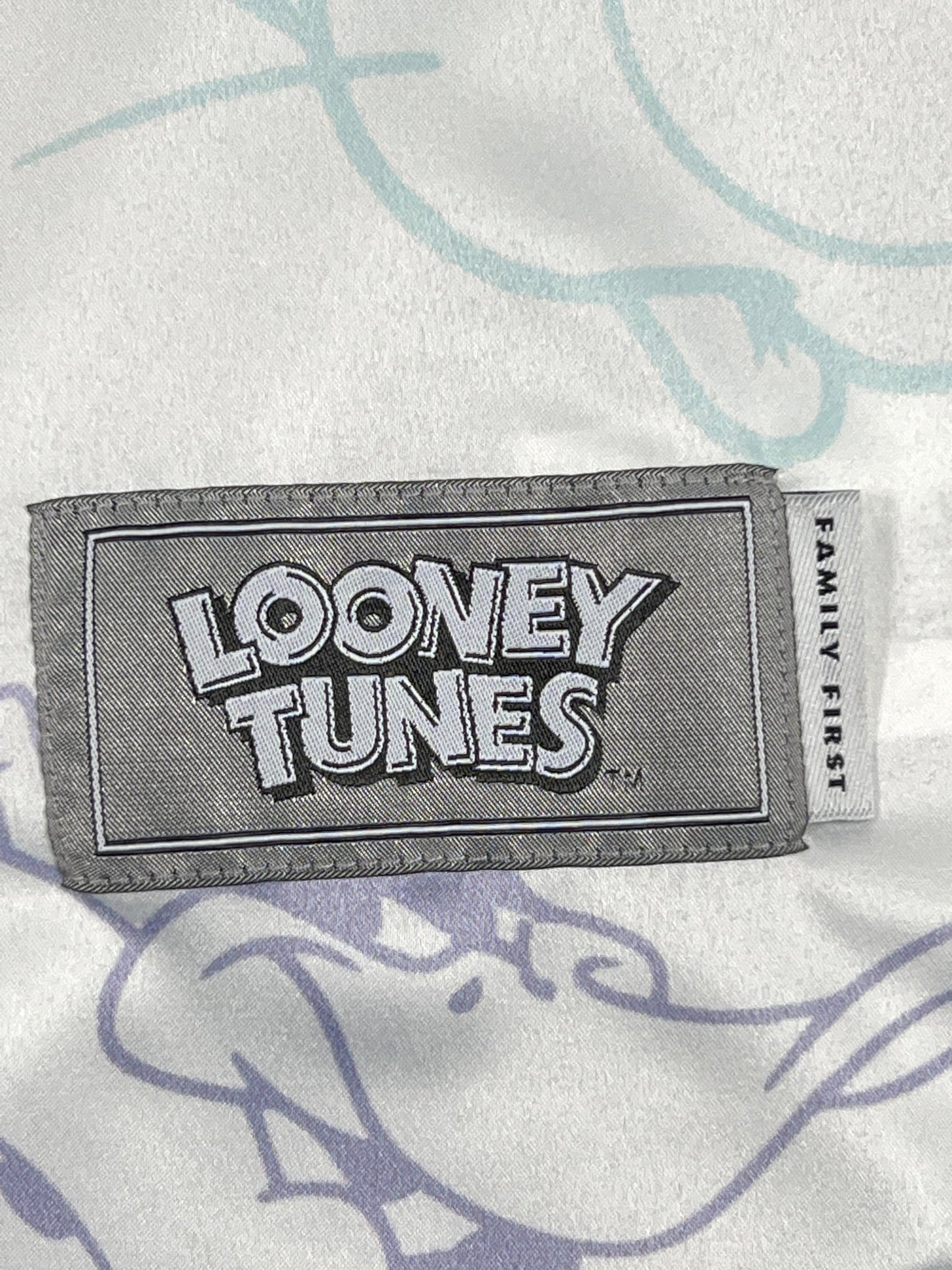 A FAMILY FIRST SHS2321 shirt in white with a label that says Looney Tunes.