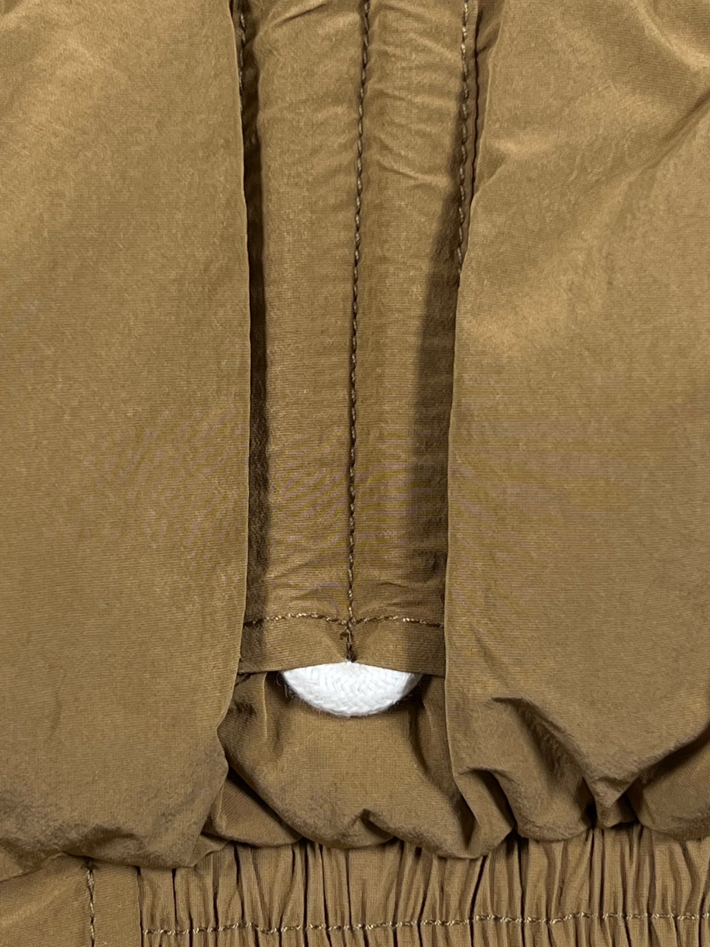 A close up of a tan, water-repellent DIESEL W-ERIC JACKET SPONGE with a zipper.