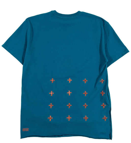 A teal blue KSUBI ECOLOGY BIGGIE SS tee with orange embroidered crosses on it.