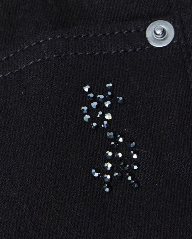 A close up of a pair of KSUBI Jeans Chitch Krystal Black denim jeans with crystal sequins on them.