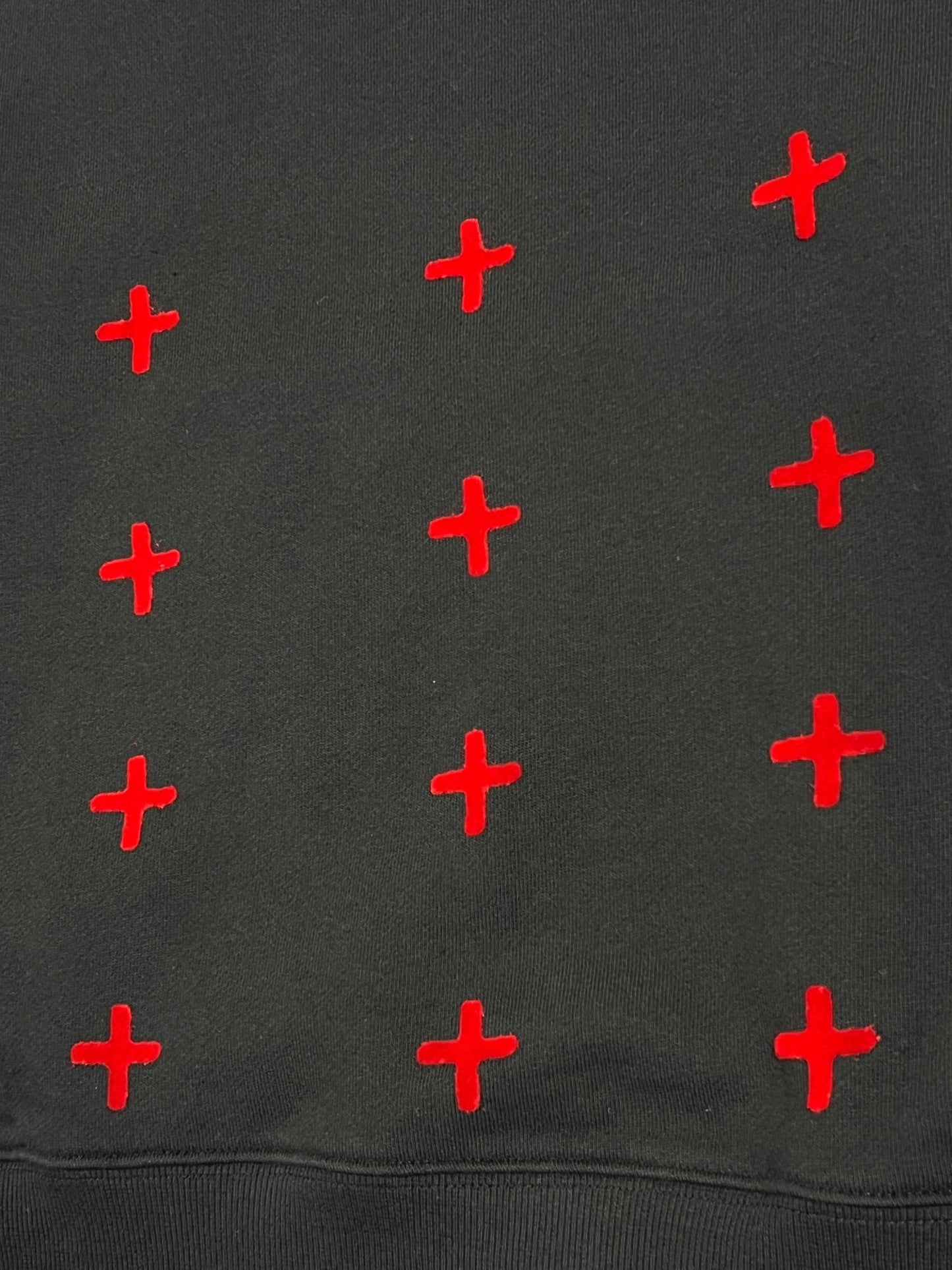 A KSUBI jet black sweatshirt with red crosses on it.