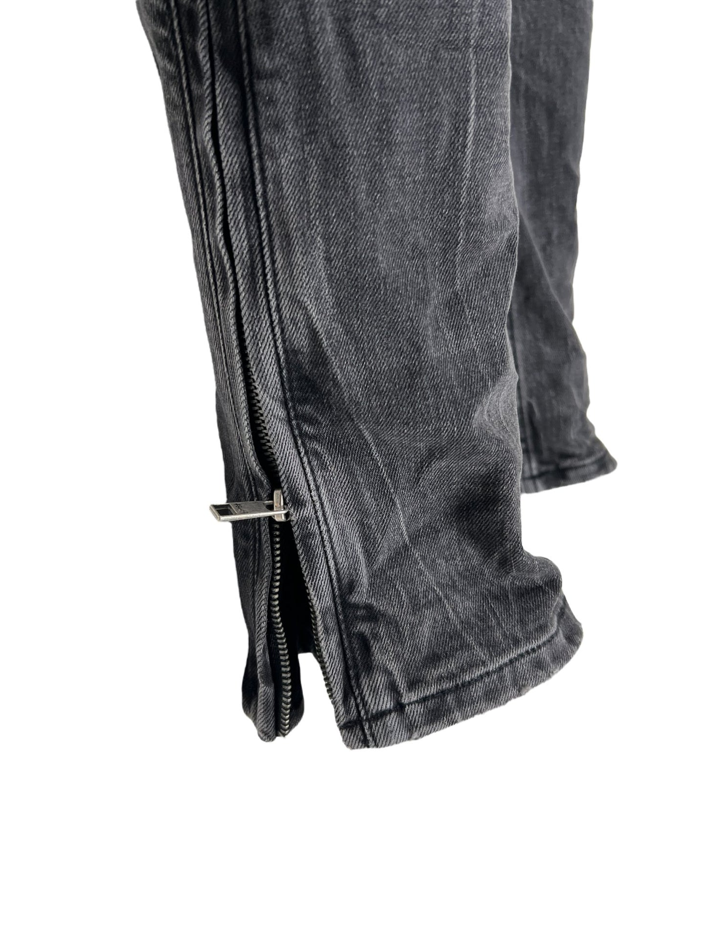 A pair of KSUBI VAN WINKLE CHAMBER BLACK jeans with zippers on the side.