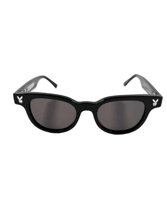 A PLEASURES black sunglasses with grey lenses, symbolizing liberation.