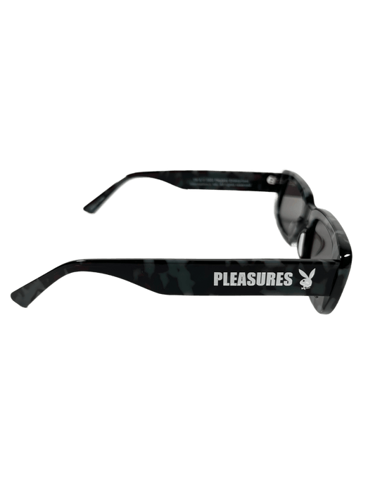 A pair of PLEASURES LIBERATION sunglasses in black with the word pleasures on them.