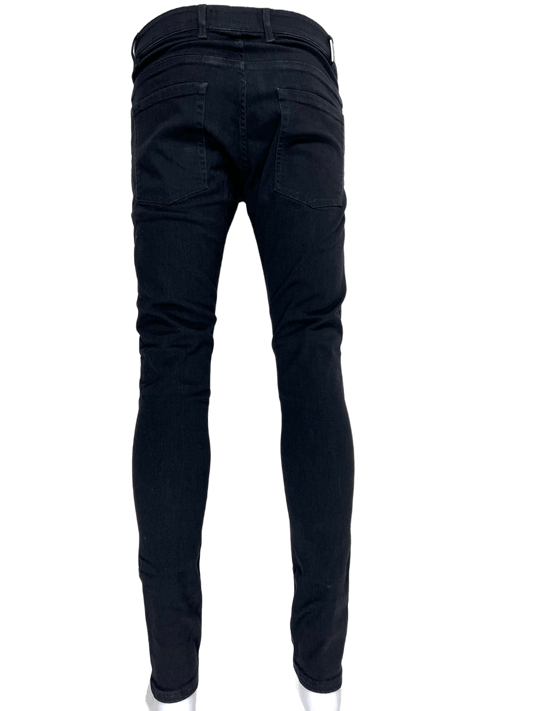 The back view of a pair of REPRESENT M07043-01 ESSENTIAL DENIM BLACK FW22 skinny fit jeans.