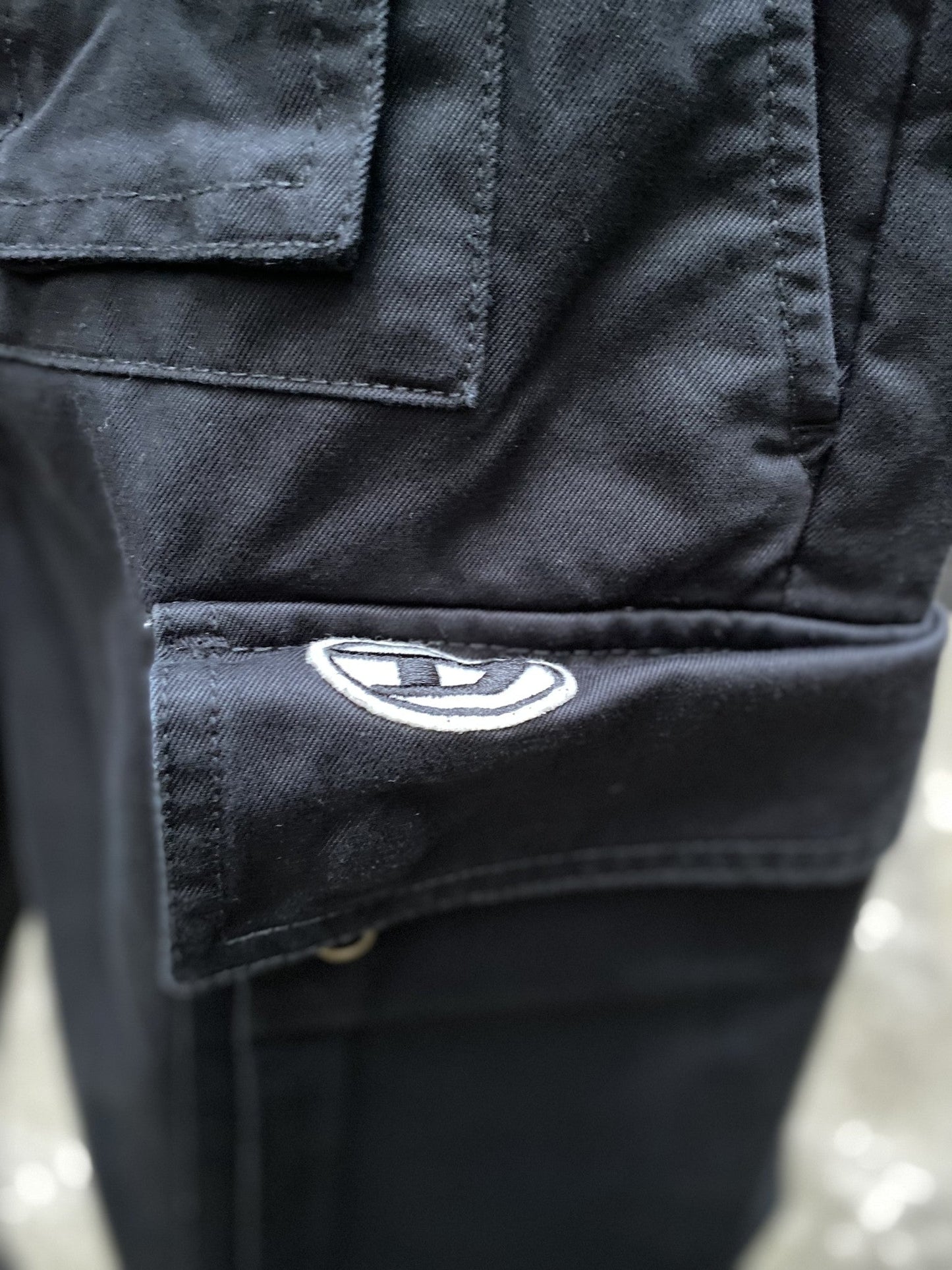 A close up of black DIESEL P-COR-CL pants with a logo on it.
