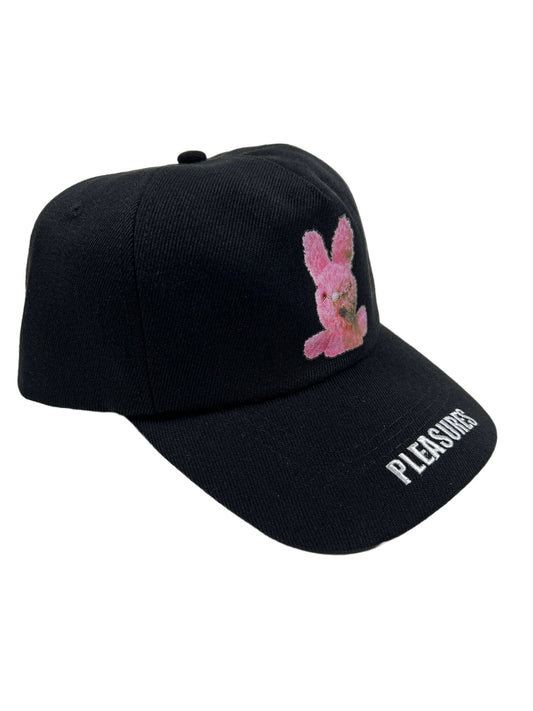 A black twill curved brim cap with a pink Pleasures bunny on it.