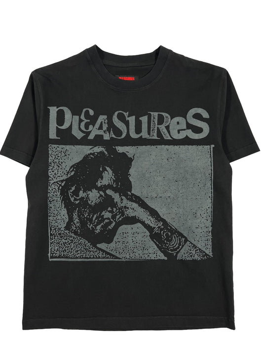 A black PLEASURES GOUGE HEAVYWEIGHT SHIRT with the words PLEASURES screen-printed on it.