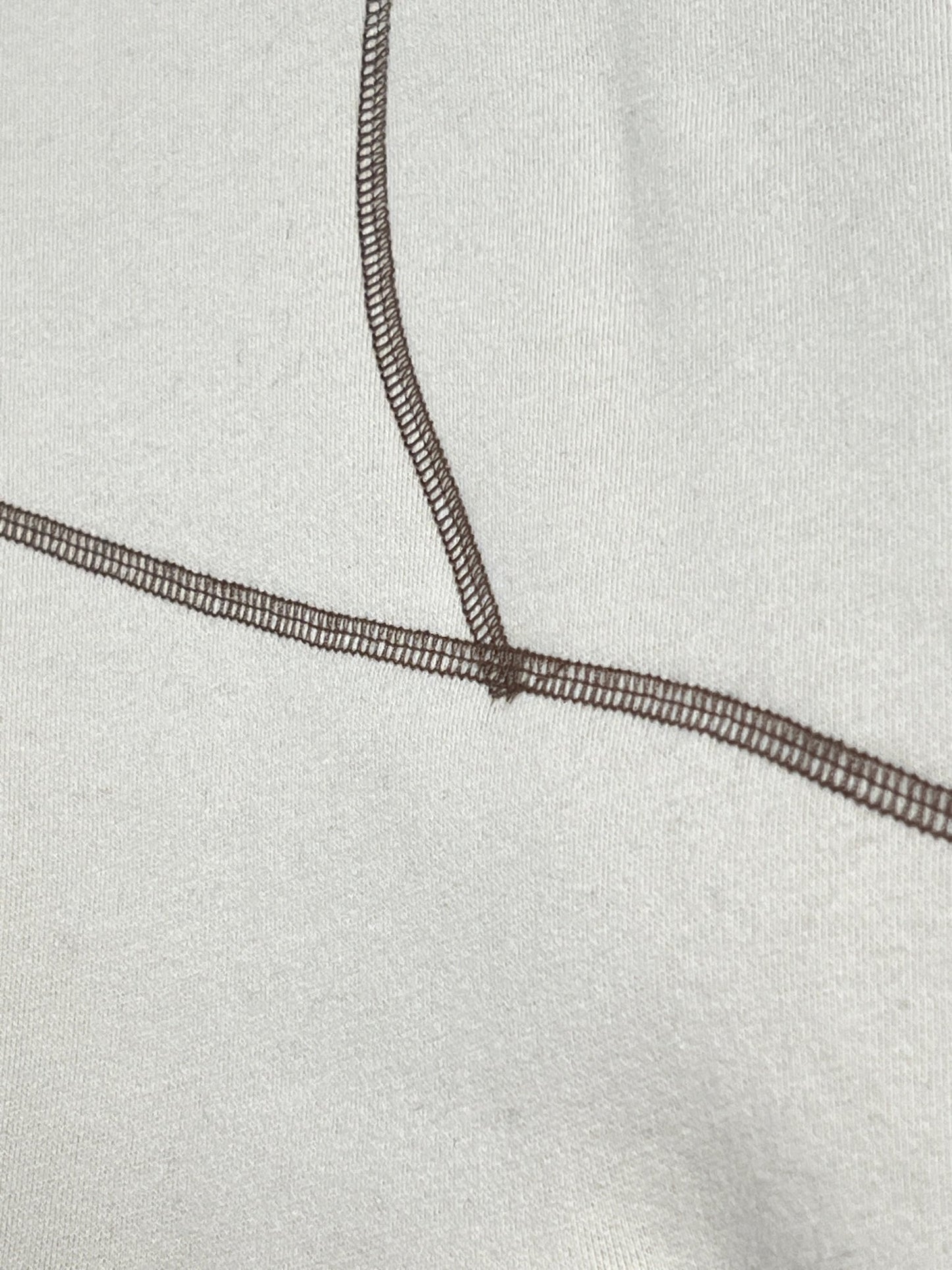 A close up of an ultra-soft PLEASURES VEIN HOODIE TAN with brown threads.