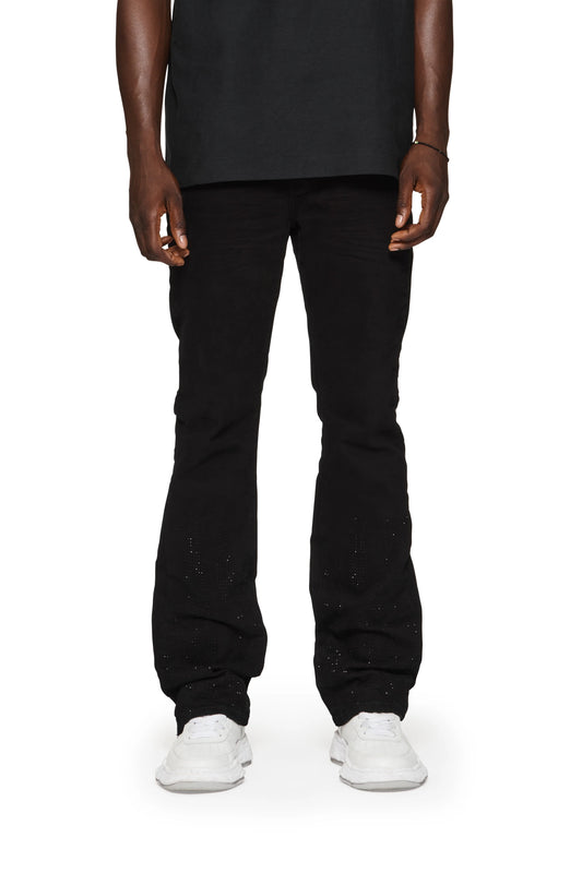 A man wearing PURPLE BRAND P004-FFBL FLAMED FLARE BLACK jeans and a white t-shirt with a flame graphic.