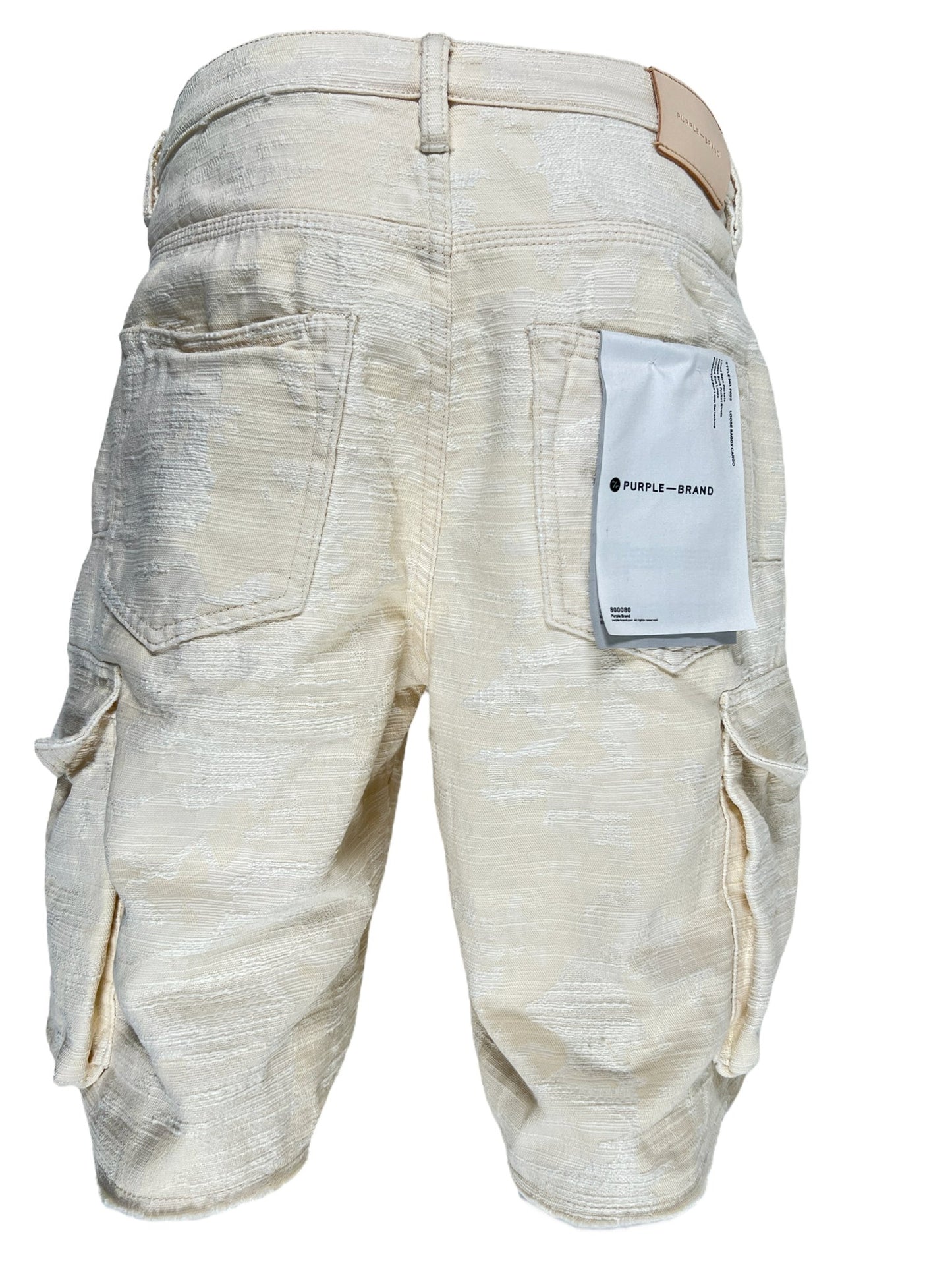 A pair of Purple Brand P022-JCSW jacquard cargo shorts in ivory with a tag on the back.