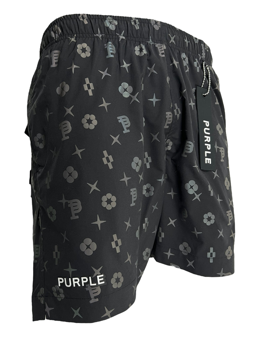 Black shorts with a vibrant print featuring various geometric shapes and symbols, including flowers and the letter "P". The word "PURPLE" is printed on the bottom of the left leg, showcasing a unique design by PURPLE BRAND PURPLE BRAND P504-PBBH ALL ROUND SHORT AOP.