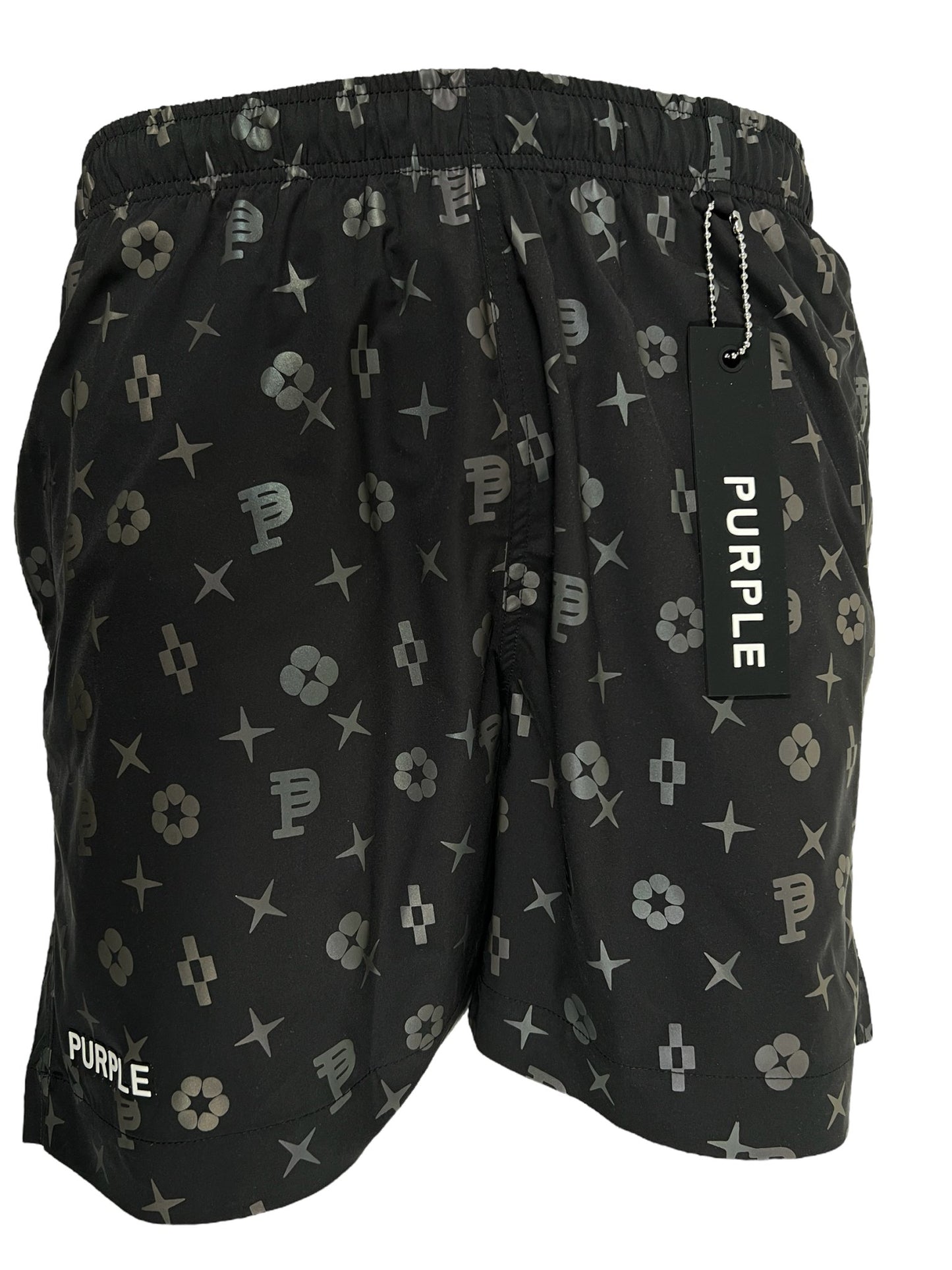 Black shorts with a unique design featuring a vibrant print of geometric shapes and symbols, a tag reading "PURPLE" attached to the waistband. These are the PURPLE BRAND P504-PBBH ALL ROUND SHORT AOP by PURPLE BRAND.