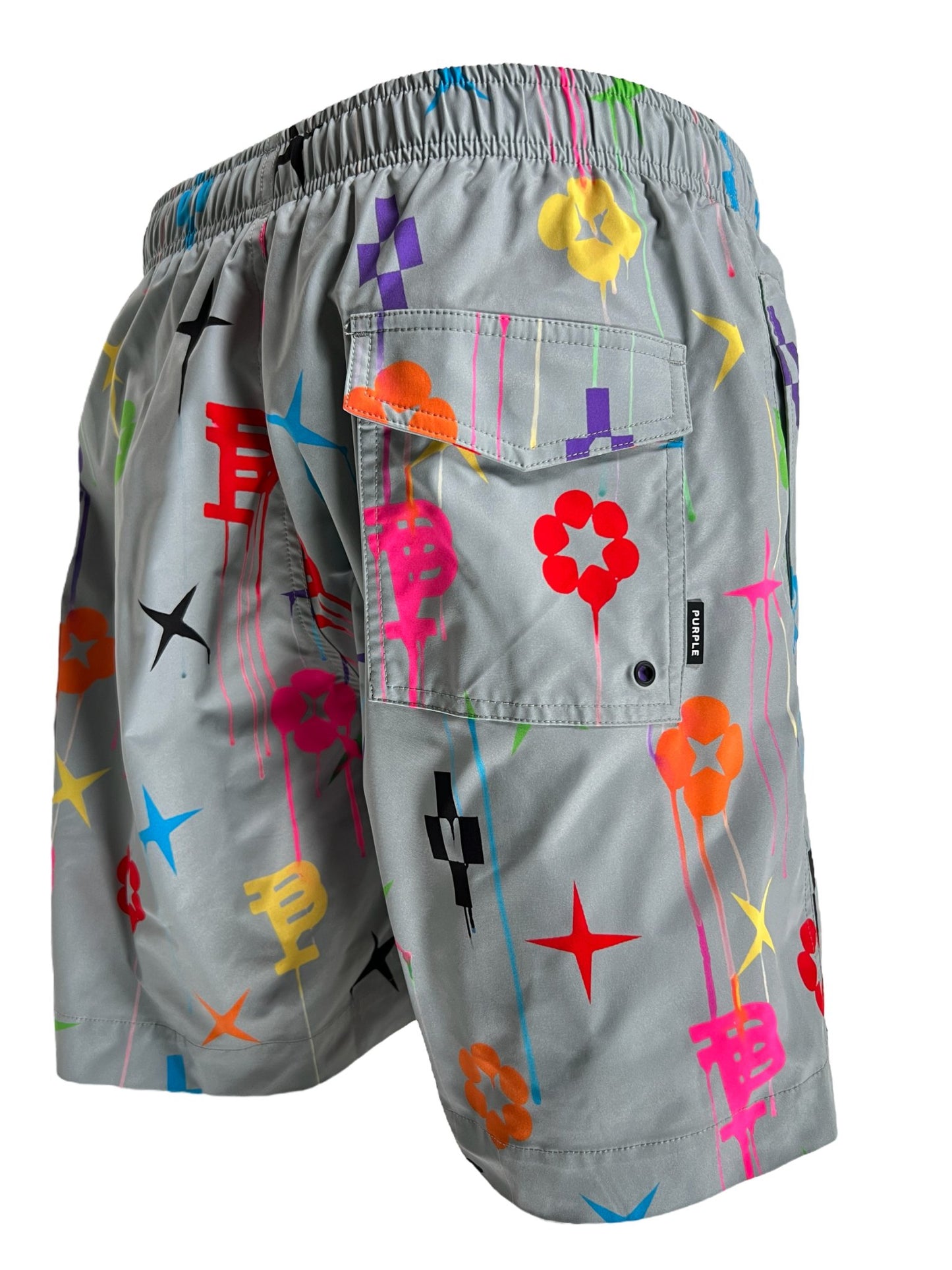 A pair of gray shorts with an elastic waistband, featuring a vibrant print of stars, flowers, and geometric shapes. These PURPLE BRAND P504-PGPM ALL ROUND SHORT AOP also include a back pocket with a button closure for added convenience.