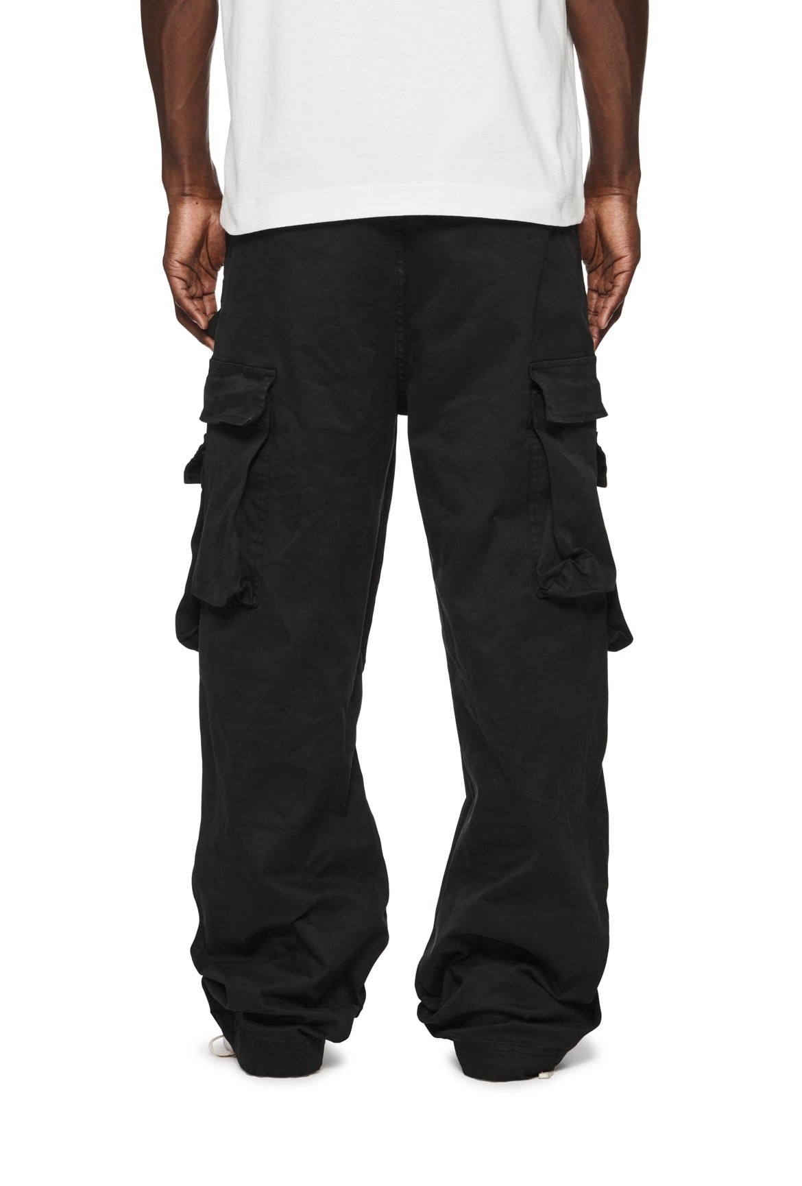 The back view of a man wearing PURPLE BRAND cargo pants, featuring numerous pockets.