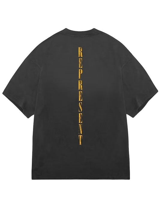The back of a black oversized fit REPRESENT MLM434-444 REBORN T-SHIRT AGED with gold lettering, made of 100% cotton.
