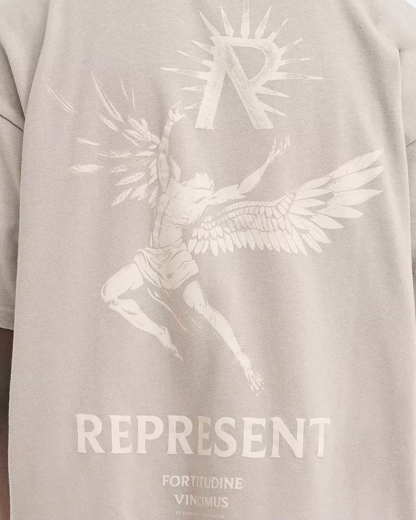 The back of a man wearing a cotton, oversized fit graphic T-shirt that says "REPRESENT.