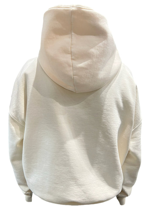 The back view of a woman wearing a stylish RHUDE HOTEL HOODIE VTG WHITE graphic hoodie in cream.
