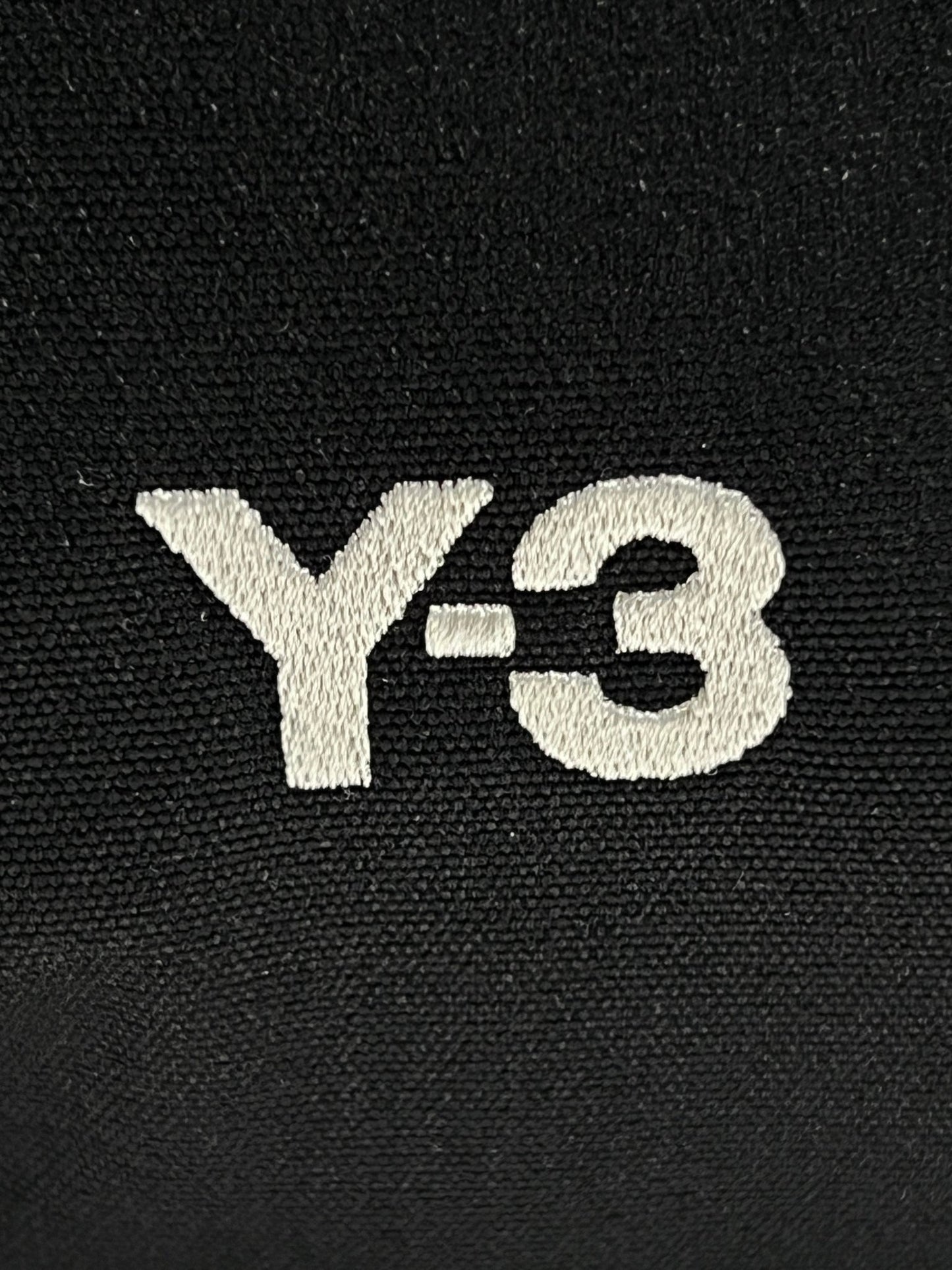 A black ADIDAS x Y-3 TRAVEL BAG IR5793 with an adjustable carry strap.