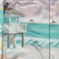 A long sleeve FAMILY FIRST Hawaiian shirt made in Italy with a painting of a beach and a lifeguard tower.