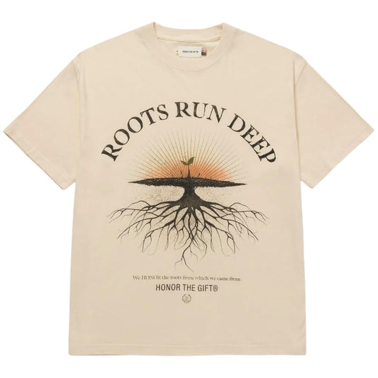 Introducing the Honor The Gift A-Spring Roots Run Deep Ss Tee in Bone from HONOR THE GIFT. This beige jersey t-shirt showcases the phrase "Roots Run Deep" along with a screen-printed tree graphic complete with roots. Below, it features the sentiment "We honor the roots from which we came from - Honor the Gift." Crafted from 100% cotton, this t-shirt offers ultimate comfort.