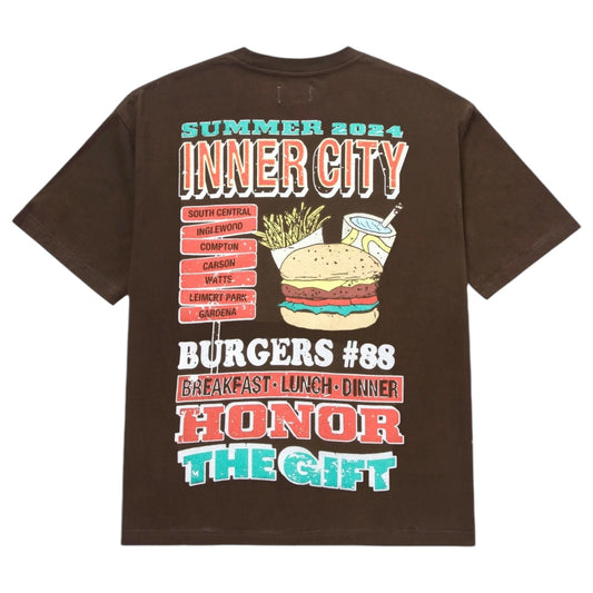 The Honor The Gift HTG Burgers SS Tee Black, made by the brand HONOR THE GIFT, is a vintage-style pocket T-shirt constructed from 100% cotton. It showcases a graphic design promoting "Summer 2024 Inner City Burgers #88," celebrating breakfast, lunch, and dinner across various city areas.