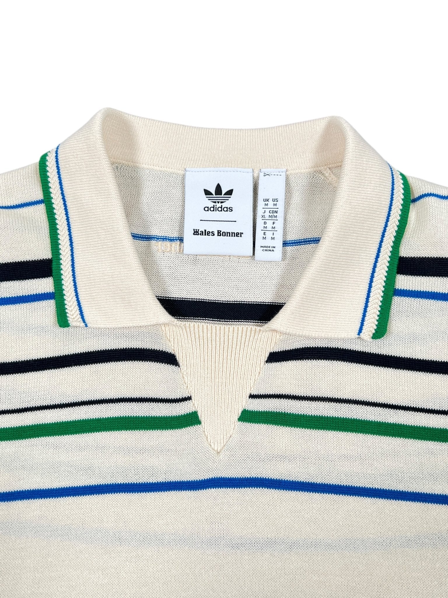 Close-up of the Adidas x Wales Bonner JM8203 WB Knit Polo WonWh, featuring multicolored horizontal stripes and visible ADIDAS x WALES BONNER brand tags on the inside collar.