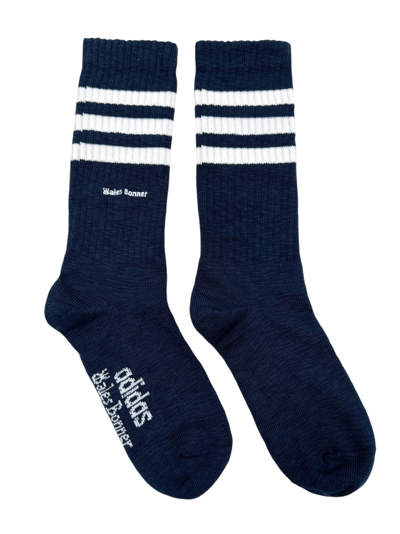 The Adidas x Wales Bonner JV8684 WB 3S Sock in NtNavy features three white stripes near the top and bold co-branding, combining classic Adidas style with Wales Bonner’s distinct touch.