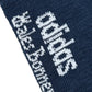 Close-up of navy blue knit fabric on ADIDAS x WALES BONNER JV8684 WB 3S Sock NtNavy, featuring the white Adidas logo and "skateboarding" text woven in white.