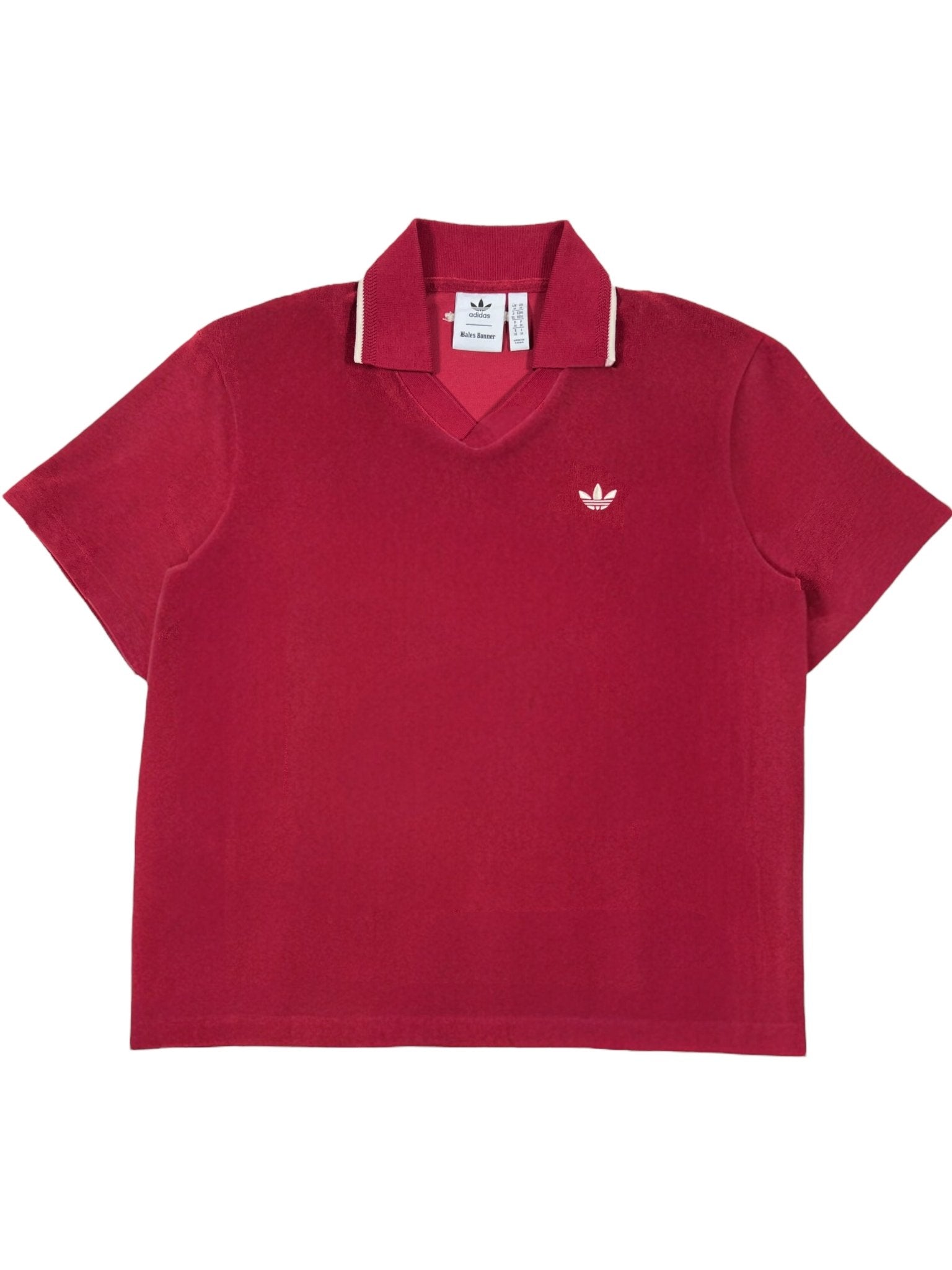 The Adidas x Wales Bonner JW1122 WB Terry Polo Cburg is a red, short-sleeve collared shirt with a white embroidered logo and contrasting collar trim, blending sporty elegance and retro style.