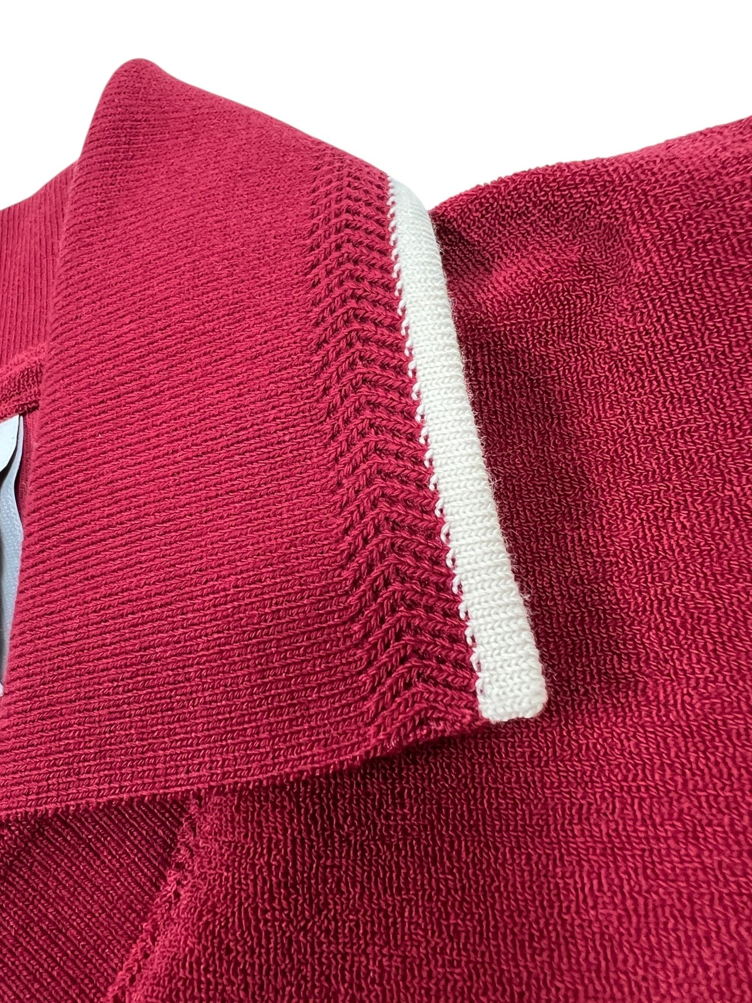 Close-up of the Adidas X Wales Bonner JW1122 WB Terry Polo Cburg by ADIDAS x WALES BONNER, featuring a red textured collar with a white stripe that showcases sporty elegance and retro-inspired style.