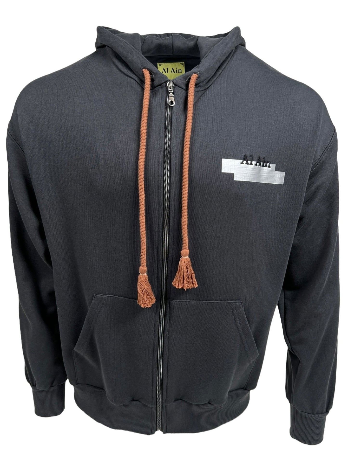 Dark gray hoodie with tassels on the zipper, featuring a white patch on the right chest labeled "AL AIN," crafted from 100% Cotton.